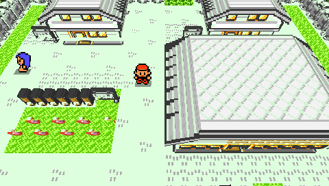 Pocket Voxel on a real PSP: Pallet Town as a voxel diorama with gabled roofs, carved bushes, flowers, an NPC and the player on the path, in per-tile color.